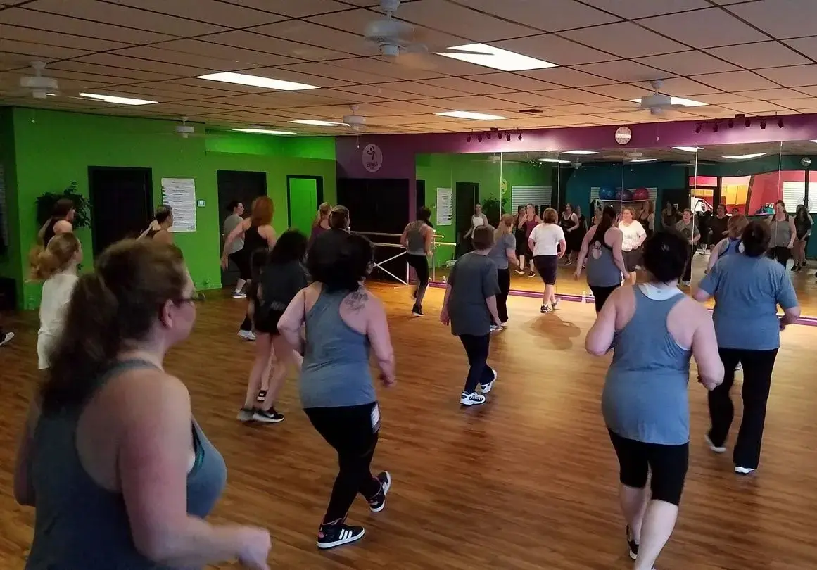 rs=w_100% A group of people in a room doing different exercises.